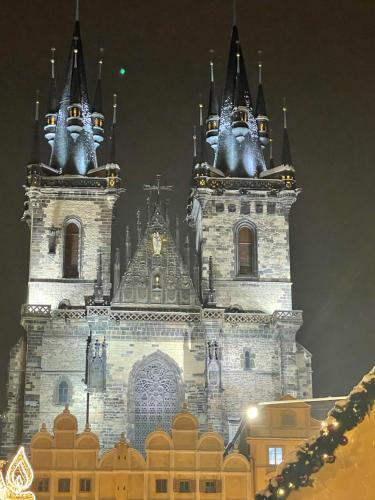 a large building with two towers at night at Kafka Prague rooms in Prague