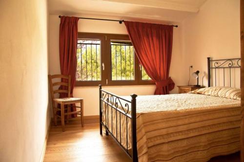 a bedroom with a bed and a chair and windows at La Ripa Del Drago in Bibbona