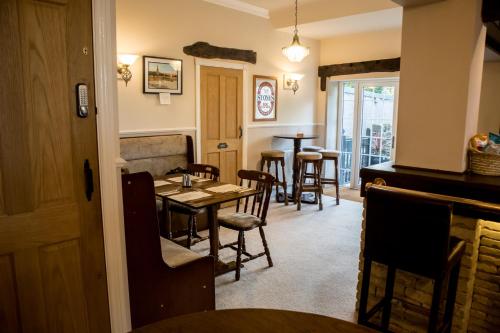 uma sala de jantar com mesa e cadeiras em The Rose Bed and Breakfast em Stainland