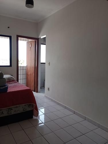 a bedroom with a bed and a tiled floor at Nossa kit in Praia Grande