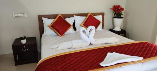 dois cisnes em toalhas brancas estão numa cama em Breezeland holidays em Padinjarathara