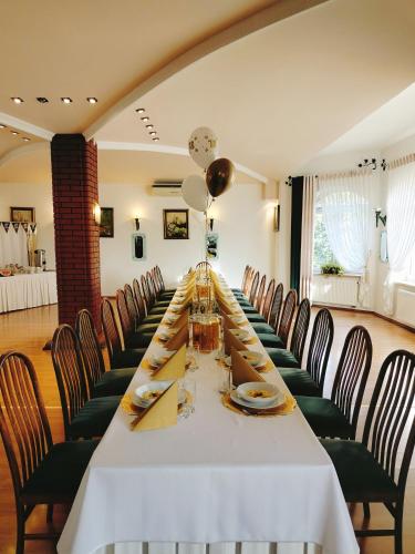 a long dining room with a long table and chairs at Zajazd u Hermanów in Olsztyn