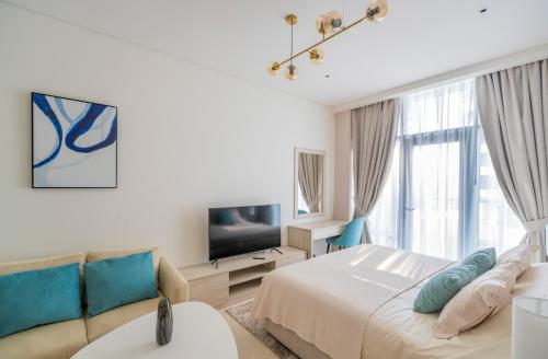 a bedroom with a bed and a couch and a tv at Studio with pool and private beach access on Palm Jumeirah in Dubai
