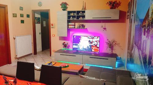 een woonkamer met een tv en een tafel bij Appartamento in Cigole