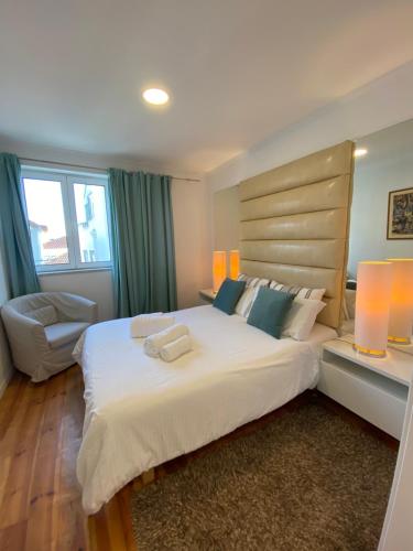 a bedroom with a large white bed and a chair at Charm of Lisbon I in Lisbon