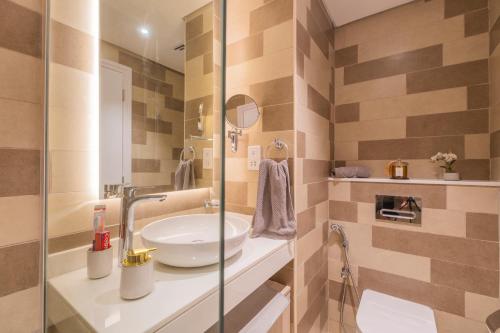 a bathroom with a sink and a glass shower at Studio with pool and private beach access on Palm Jumeirah in Dubai