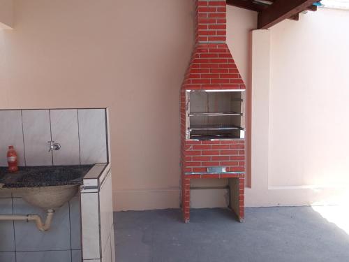 a kitchen with a brick oven in a room at Recanto WL in Olímpia