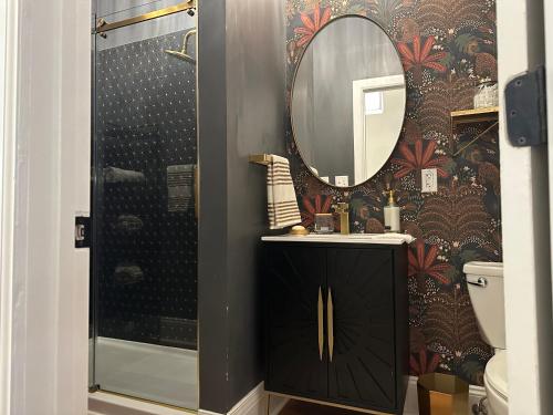 a bathroom with a black vanity and a mirror at The Historic Lyric Penthouse with Private Rooftop in Cincinnati