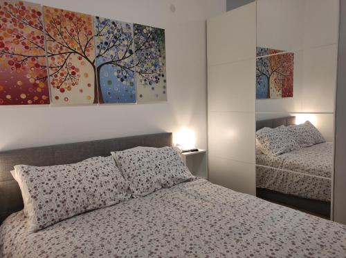 a bedroom with a bed and a tree painting on the wall at KAIROS RESIDENCE in Parma