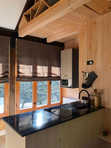 una cocina con encimera negra y algunas ventanas en Kuća za odmor “Dobra” - Skrad, Gorski kotar en Skrad