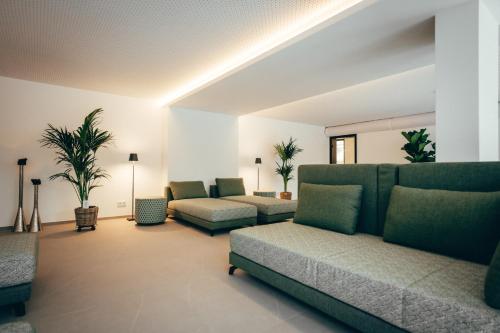 a living room with couches and tables and plants at Landidyll Hotel Restaurant Weidenbrück & SPA in Swisttal