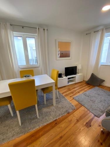a living room with a white table and yellow chairs at Charm of Lisbon I in Lisbon