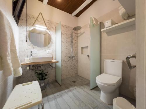 a bathroom with a toilet and a sink and a mirror at Casa Rural Venus in Alcalá