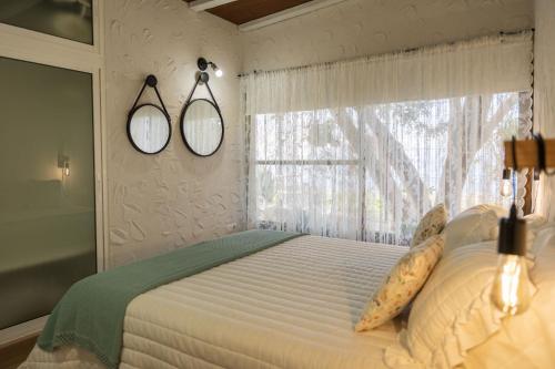una camera da letto con un letto con due specchi sul muro di Casa Rural Venus a Alcalá