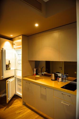 a kitchen with a sink and a refrigerator at Premium apartments - the star of Batumi Palace in Batumi