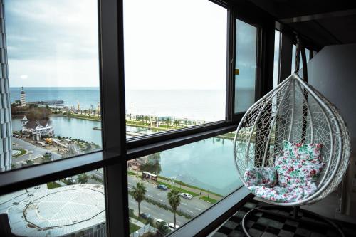a hanging chair in a room with a view of the ocean at Premium apartments - the star of Batumi Palace in Batumi