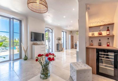 un salon avec une cheminée et un vase de fleurs dans l'établissement Villa La Bastide l Authentic & Pool l Shellter Rentals, à Saint-Tropez