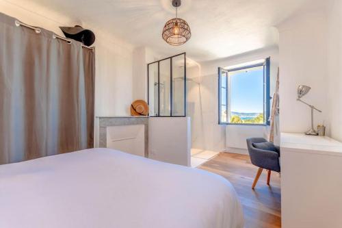 une chambre avec un lit, une chaise et une fenêtre dans l'établissement Villa La Bastide l Authentic & Pool l Shellter Rentals, à Saint-Tropez