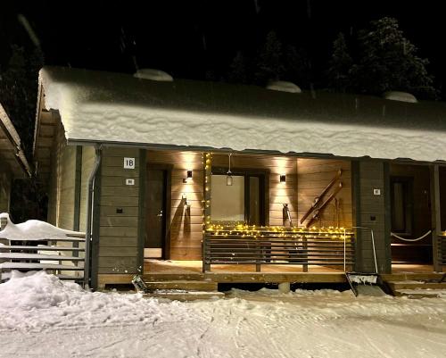 un edificio cubierto de nieve por la noche con luces en Pyhä Snowflake, en Pyhätunturi