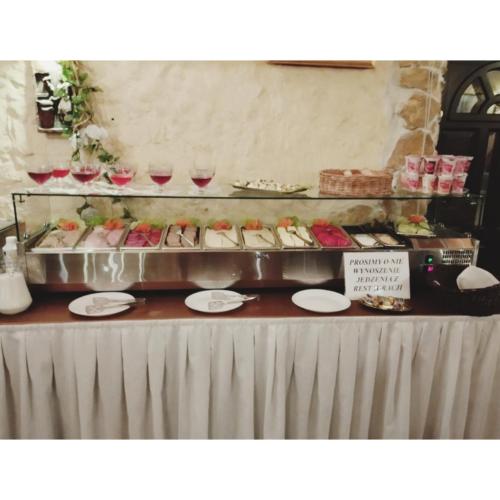 a table with a buffet of food and glasses of wine at Motel Tower in Toruń