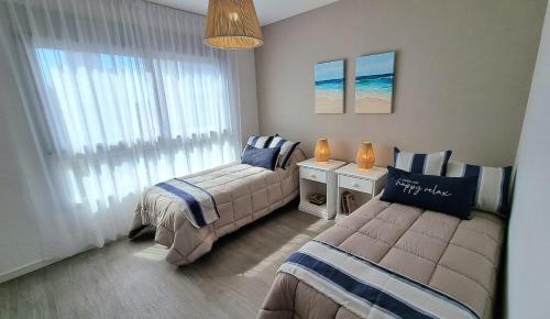 1 dormitorio con 2 camas y ventana en Piso Premium Vistas Mar & Golf en Mar del Plata