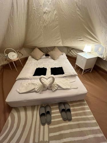 a bed with a pair of slippers on top of it at Swiss Hill View in Phop Phra