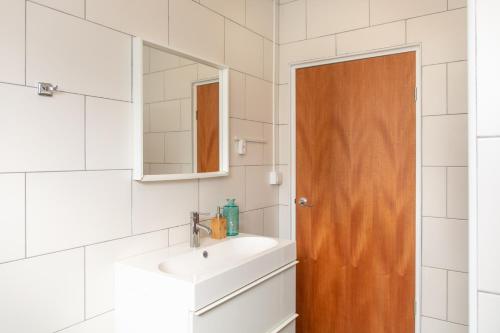een badkamer met een wastafel en een spiegel bij Playa Feliz Apartments Bonaire in Kralendijk
