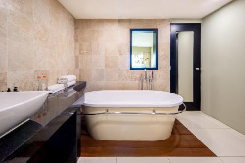 a bathroom with a tub and a sink at Crowne Plaza Villahermosa by IHG in Villahermosa