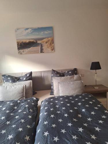 a bedroom with two beds and a couch with stars at Apartment Annies Deichliebe in Krummhörn