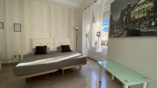 マドリードにあるStay Inn Madridのベッドルーム1室(ベッド1台、ガラス張りのテーブル付)