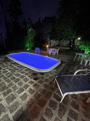 a large blue swimming pool at night at Pousada Dona Carmem Ubatuba in Ubatuba