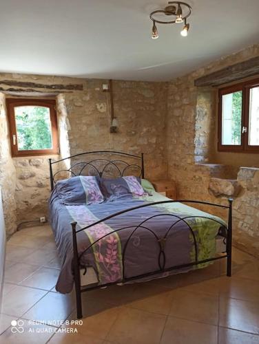 - une chambre avec un lit dans une pièce dotée de murs en pierre dans l'établissement La Francotine, à Lherm