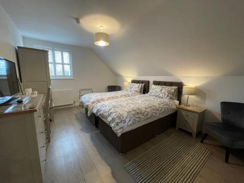a bedroom with a bed and a desk and a chair at Cotswold Hare in Cirencester