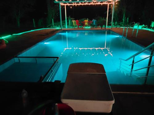 a swimming pool at night with a bench in it at The walkway cottage in Alibaug