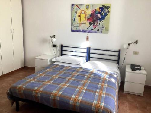 um quarto com uma cama com um cobertor xadrez azul em Casa Balani em Assis