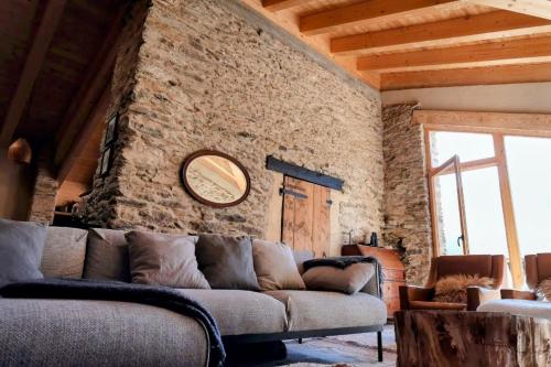 un soggiorno con divano e parete in pietra di Espectacular Chalet de Montaña Pirineos, Burg a Burg