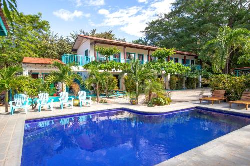 una casa con piscina frente a una casa en Hotel Diversion Tropical en Brasilito