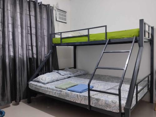 a bunk bed with a ladder and a bunk bed with a mattress at Vin's Place Rentals in Tagum