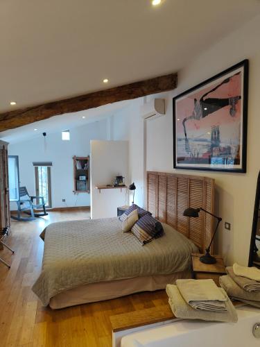 une chambre avec un grand lit et un salon dans l'établissement HAMEAU DE LA SAVOUILLANE, à Buis-les-Baronnies