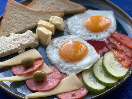 een bord ontbijtproducten met eieren en brood bij 4 Seasons in Karakol