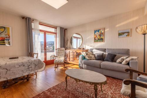 a living room with a couch and a table at Entre VILLE et NATURE - Les Hauts de Clermont avec GARAGE gratuit in Clermont-Ferrand
