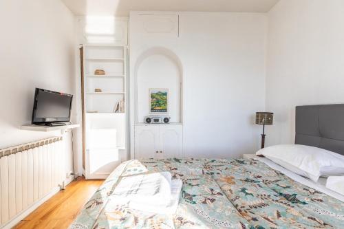 a white bedroom with a bed and a tv at Entre VILLE et NATURE - Les Hauts de Clermont avec GARAGE gratuit in Clermont-Ferrand