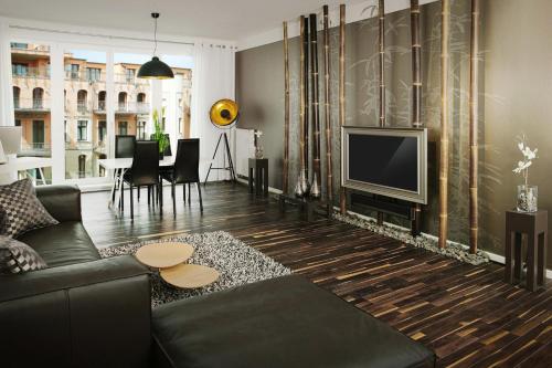 uma sala de estar com um sofá e uma televisão em Your Most Beautiful Home in Mitte – New! em Berlim