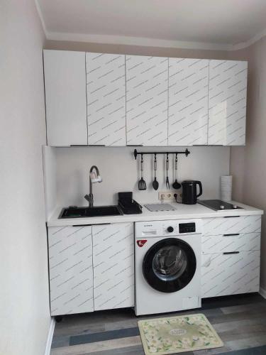 eine Küche mit einer Waschmaschine und einem Waschbecken in der Unterkunft Downtown cozy flat in Ulaanbaatar