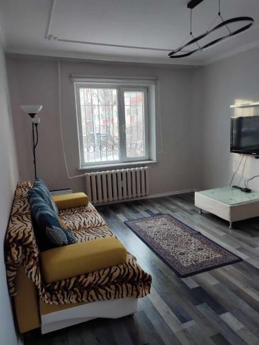 a living room with a couch and a television at Downtown cozy flat in Ulaanbaatar