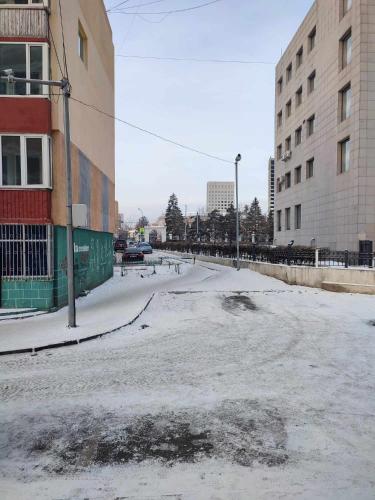 an empty street with snow on the ground at Downtown cozy flat in Ulaanbaatar