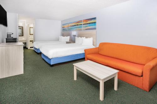 a hotel room with a bed and a couch at Days Inn & Suites by Wyndham Colonial in Williamsburg