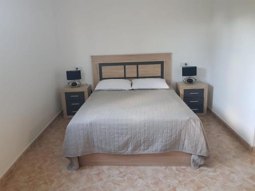 a bedroom with a large bed with two night stands at Bungalow Calpe con Piscina, Tenis, Parking in Calpe