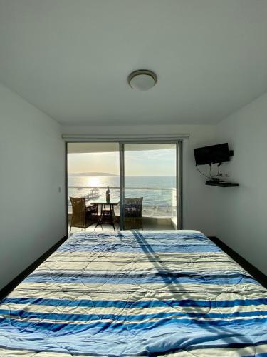 1 dormitorio con cama y vistas al océano en Condominio Nuevo Paracas - Sotavento, en Paracas