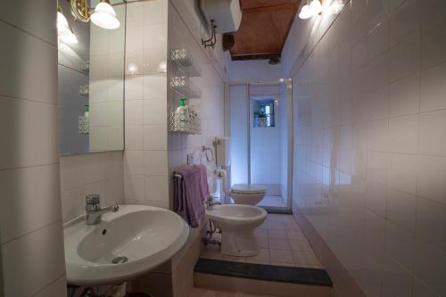 a white bathroom with a sink and a toilet at Oasi nel Cuore di Lucca, super centrale e luminoso in Lucca